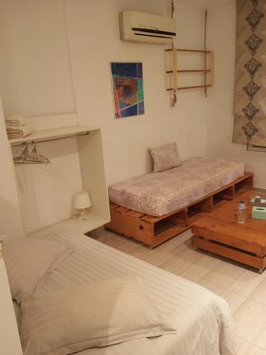 a bedroom with two beds and a table in it at Charmant studio à Sfax in Sfax
