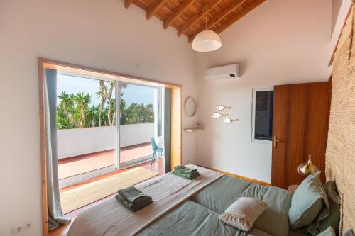 a bedroom with a large bed and a large window at Casa Silke in Vila Franca do Campo