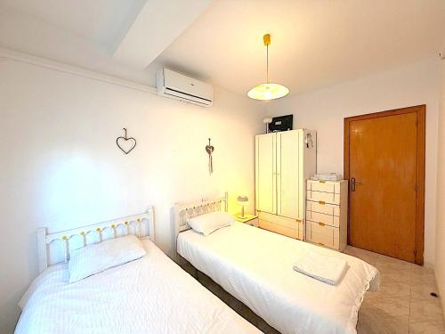 a bedroom with two beds and a refrigerator at Santa Pola port in Santa Pola