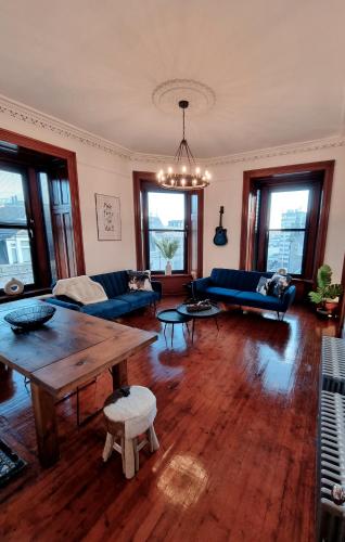 a living room with a wooden table and blue couches at Luxury 2 bedroom city centre apartment with panoramic views and high ceilings in Aberdeen