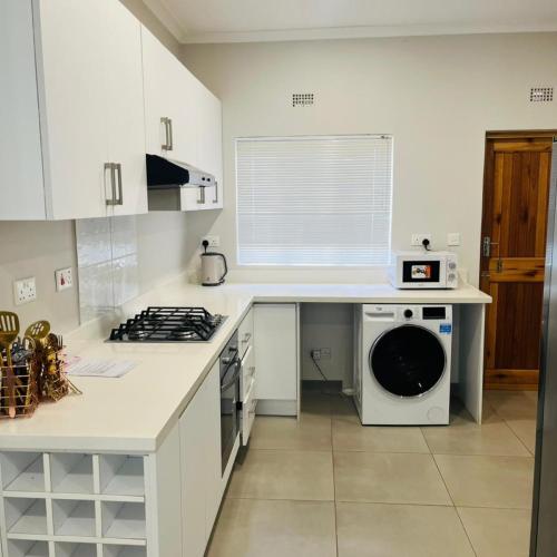 a kitchen with a washer and dryer on a counter at 219 Contours Luxury Apartment in Victoria Falls