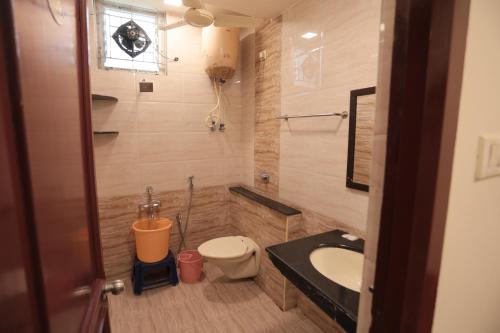 a bathroom with a sink and a toilet at Hotel Rayas in Kumbakonam
