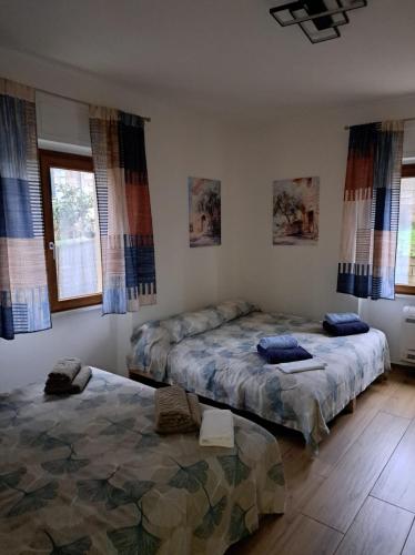 a bedroom with two beds and two windows at Da Tea in Olzai