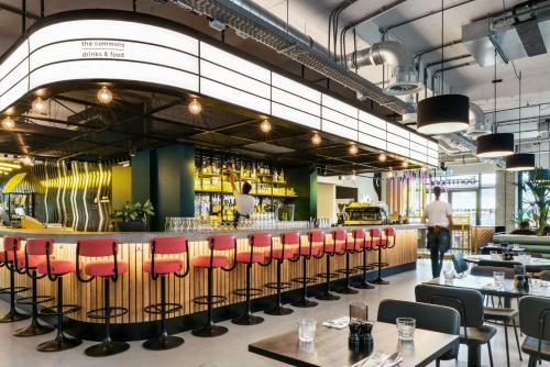 a restaurant with red chairs and a bar at The Social Hub Amsterdam West in Amsterdam