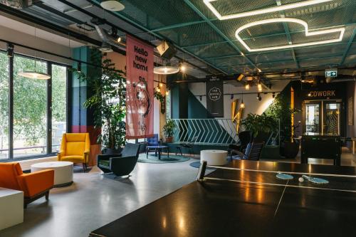 a lobby with chairs and tables in a building at The Social Hub Amsterdam West in Amsterdam