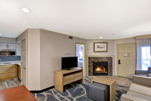 a living room with a television and a fireplace at Homewood Suites by Hilton Windsor Locks Hartford in Windsor Locks