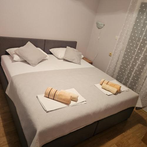 a bed with two plates with towels on it at Pansion San Pietro in Međugorje