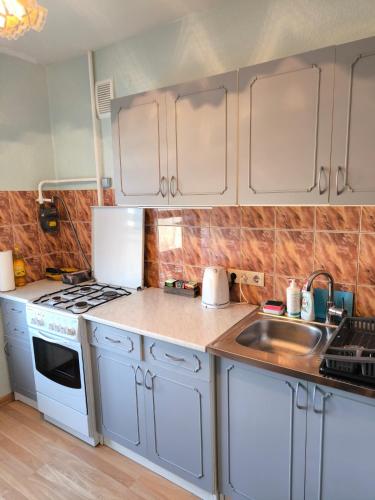 a kitchen with white cabinets and a sink at Central Point Apartments in Rēzekne