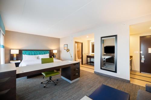 a hotel room with a desk and a bedroom at Hampton Inn by Hilton Winnipeg in Winnipeg