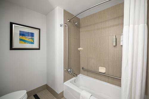 a bathroom with a bath tub and a toilet at Hampton Inn by Hilton Winnipeg in Winnipeg