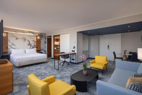 a hotel room with a bed and yellow chairs at Hilton Barcelona in Barcelona
