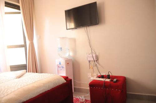 a bedroom with a bed and a tv on the wall at Azure View Studio with pool in Kiahuria
