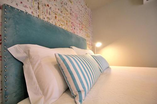 a bed with a green headboard and a pillow at RestOnDouro Oporto Studio in Valbom