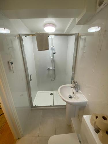 a white bathroom with a shower and a sink at Riverside 2 Bedroom Apartment - Central Location in Kingston upon Thames