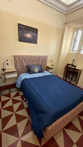 a bedroom with a large bed with a blue blanket at B&B Galileo Galilei in Caserta