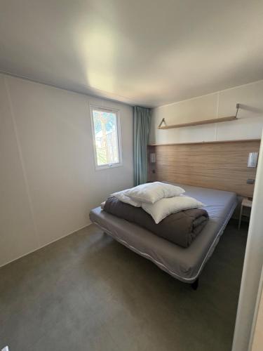 a bedroom with a large bed with a window at Nadege in Lège-Cap-Ferret