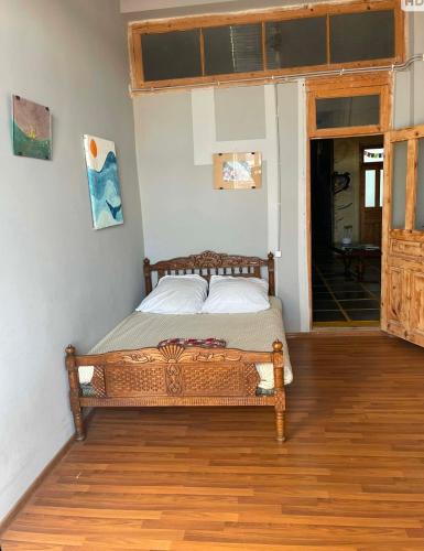 a bed in a room with a wooden floor at Nomads Nest in Kutaisi