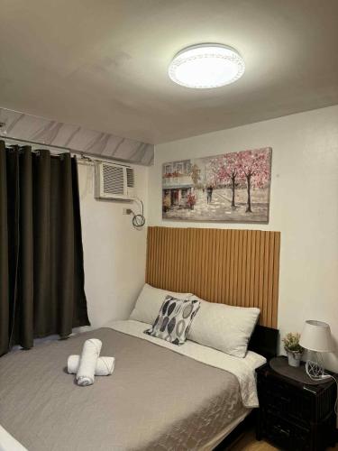 a bedroom with a bed with a stuffed animal on it at Super Cozy Condo Davao in Davao City
