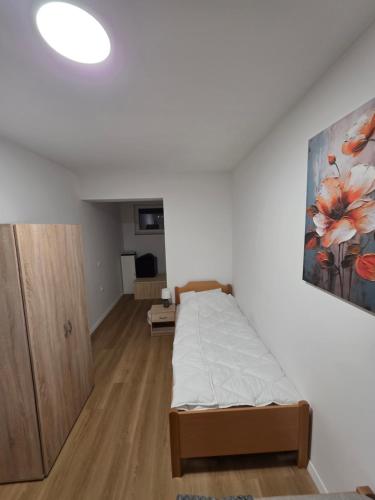a bedroom with a bed and a painting on the wall at Center- Podčetrtek in Podčetrtek