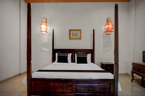 a bedroom with a wooden bed and two lamps at Collection O near University of Sumatera Utara formerly Huber Apartment in Medan