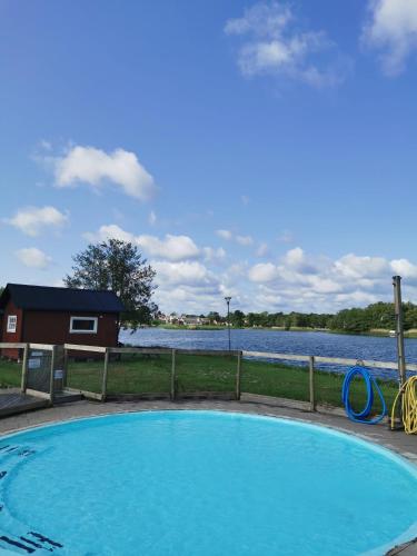a swimming pool next to a body of water at Stuga1-6 Dalskärs camping Badrum i Servicehus in Bergkvara