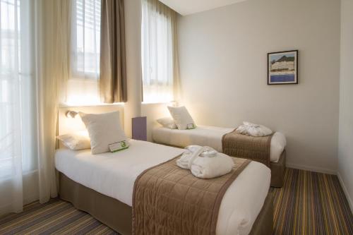 Llit o llits en una habitació de Privilège Appart Hôtel Saint Exupéry