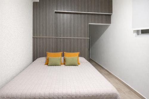 a bed in a room with two pillows on it at Departamento moderno, equipado full en vicente López ,ubicacion inmejorable a 100 metros del tren in Florida