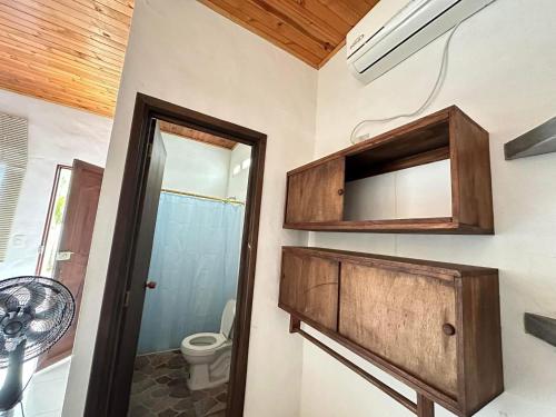 a bathroom with a toilet and a wooden cabinet at Casa Montpellier in Honda