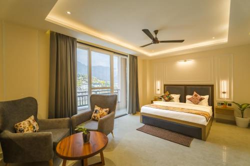 a hotel room with a bed and a large window at Tripli Hotels Solune in Rishīkesh