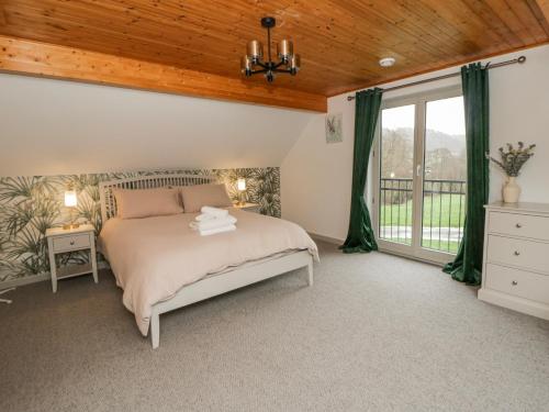 a bedroom with a bed and a wooden ceiling at Willow Lodge in Knighton