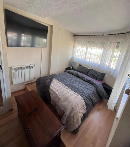 a bedroom with a bed and a wooden table at Seafront Chalet Muchavista direct beach access in El Campello