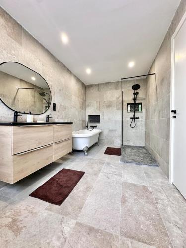a bathroom with a tub and a sink and a mirror at Seafront Chalet Muchavista direct beach access in El Campello
