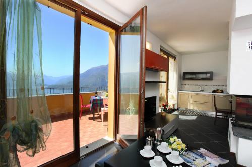 a kitchen and a living room with a large window at Alto Perledo in Perledo