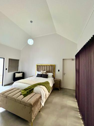 a bedroom with a large bed with a wooden headboard at EHH Accommodation Hentiesbay in Hentiesbaai