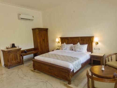 a bedroom with a large bed and a table at JD Tara Resort in Ranakpur