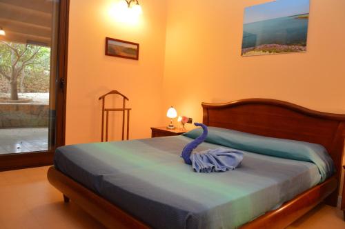 Un dormitorio con una cama con una bata azul. en Villa Giulia - Sicilian Luxury Garden, en Punta Secca