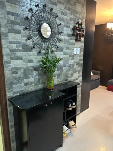 a mirror on a brick wall with a black desk at R and RMI CONDOTEL in Baguio