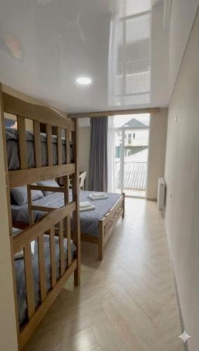a bedroom with two bunk beds and a balcony at TIRKIUS House in Kobuleti