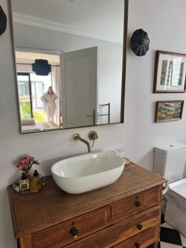 a bathroom with a white sink and a mirror at Dornoch House, Gowrie Village in Nottingham Road