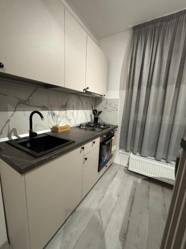 a kitchen with white cabinets and a sink and a window at The Urban Line by D'or Selection in Bucharest
