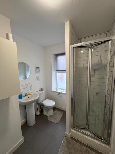 a bathroom with a shower and a toilet and a sink at King Street Rooms in Liverpool