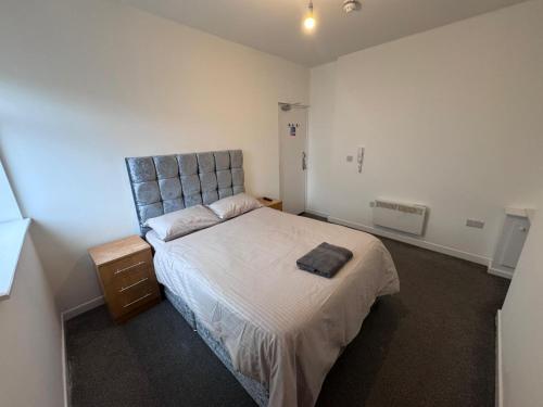 a bedroom with a bed with a gray headboard at King Street Rooms in Liverpool