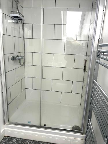 a shower with a glass door in a bathroom at Salmon Leap Hotel in Whitby