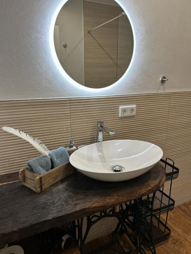 a bathroom sink with a mirror on a wooden table at Hostel Farm Ostedt in Wrestedt