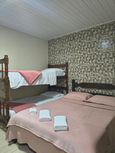 two beds in a room with towels on them at Pousada do Trevo in Paraty