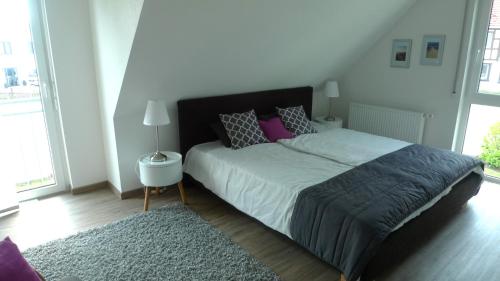 a bedroom with a bed with purple pillows and a rug at Ferienhaus "Dorf-Glück" in Brilon