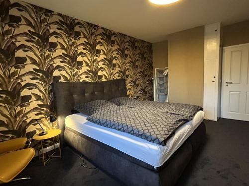 a bedroom with a bed with a black and white wallpaper at Hostel Farm Ostedt in Wrestedt