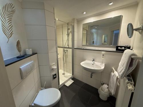 a white bathroom with a toilet and a sink at Hotel gold Self-Check-In-Hotel Pfullendorf in Pfullendorf