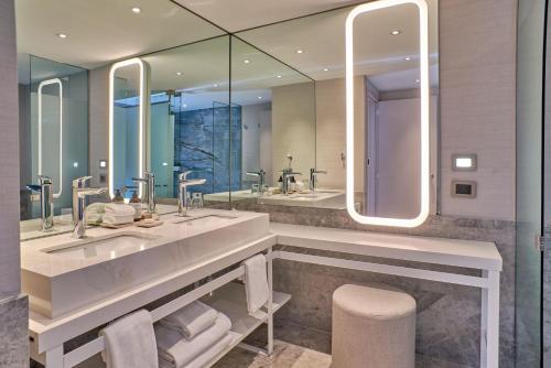a bathroom with two sinks and two mirrors at Hilton Buenos Aires in Buenos Aires