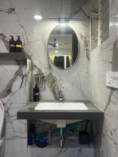 a bathroom with a sink and a mirror at Atelier Sol- ultra luxe aparthotel near airport in Pune